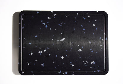Black chopping board with white and grey speckles
