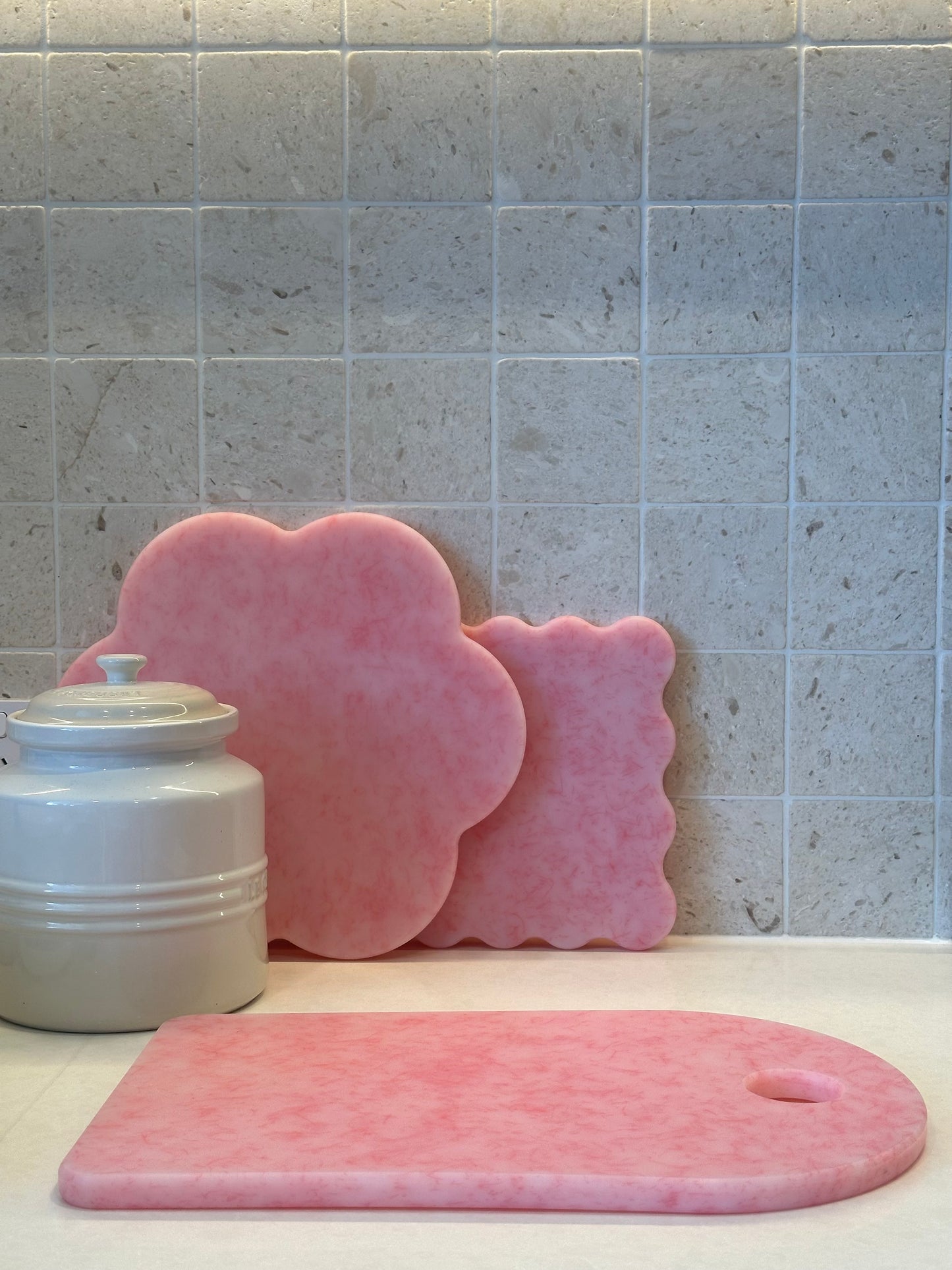 Pink chopping board with round end and hole for hanging
