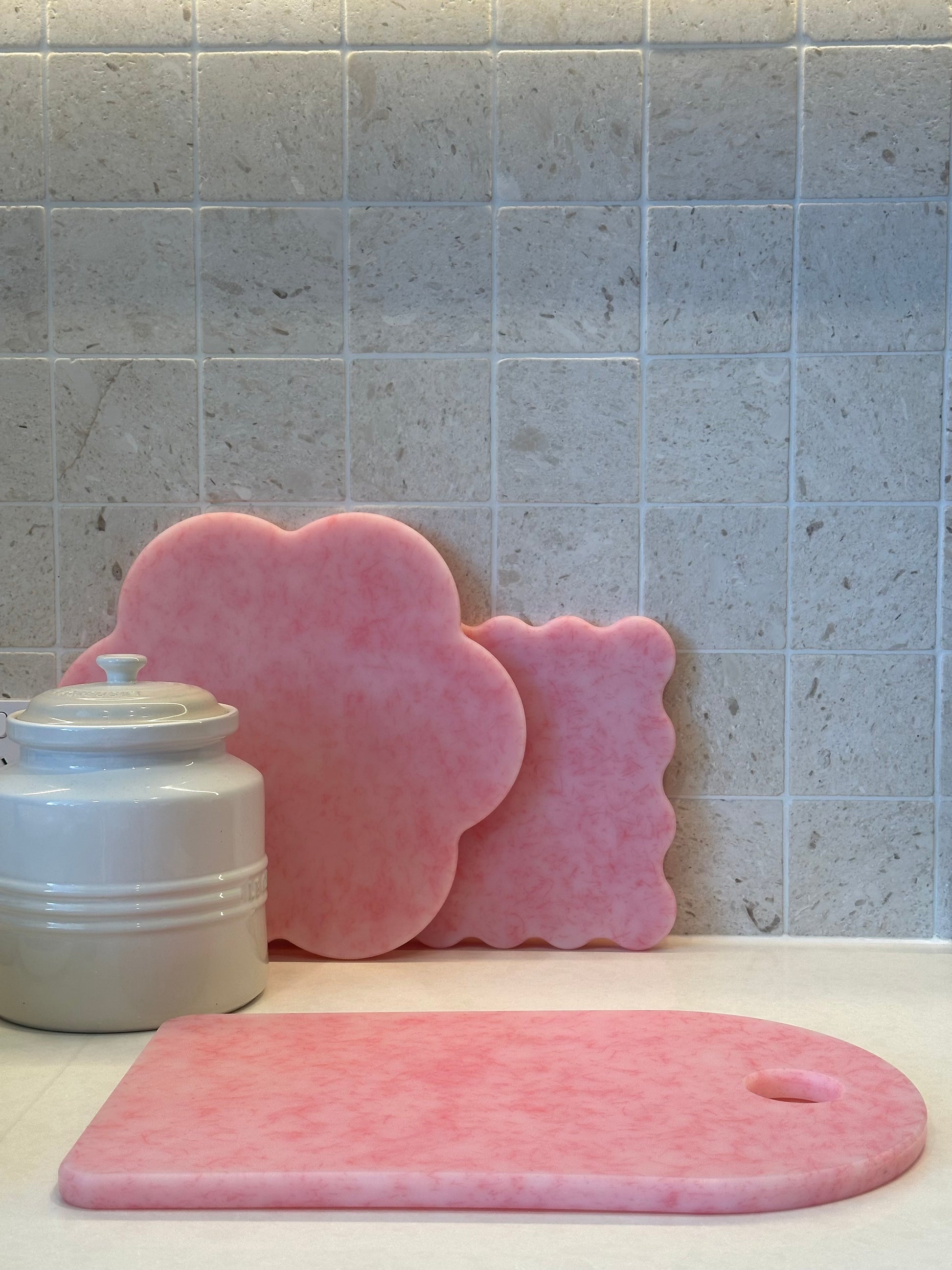 Pink chopping board with round end and hole for hanging
