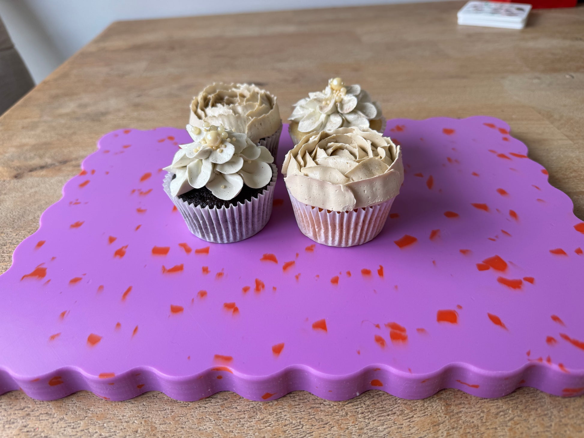Pink wavy chopping board with orange speckles.