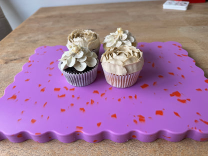 Pink wavy chopping board with orange speckles.