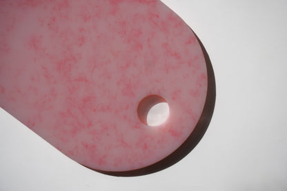 Pink chopping board with round end and hole for hanging