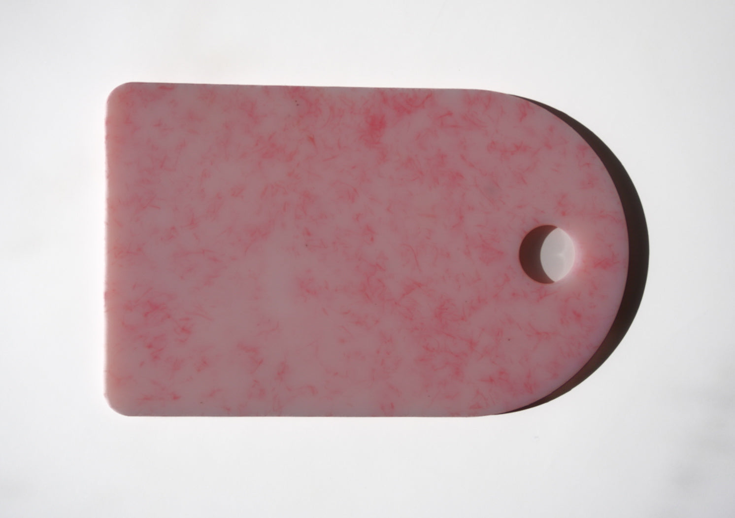 Pink chopping board with round end and hole for hanging