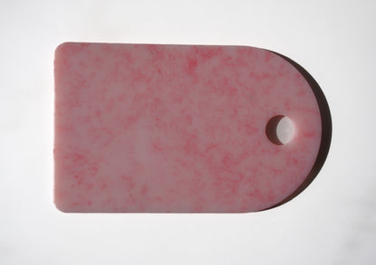 Pink chopping board with round end and hole for hanging