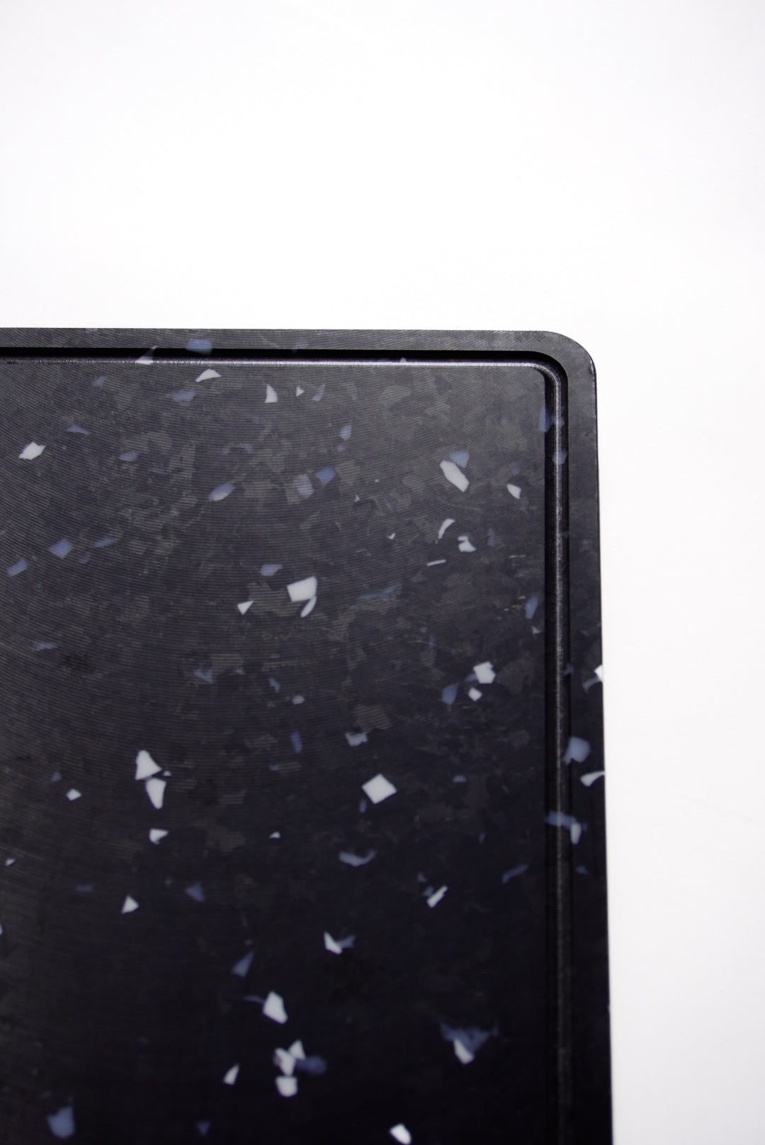 Black chopping board with white and grey speckles