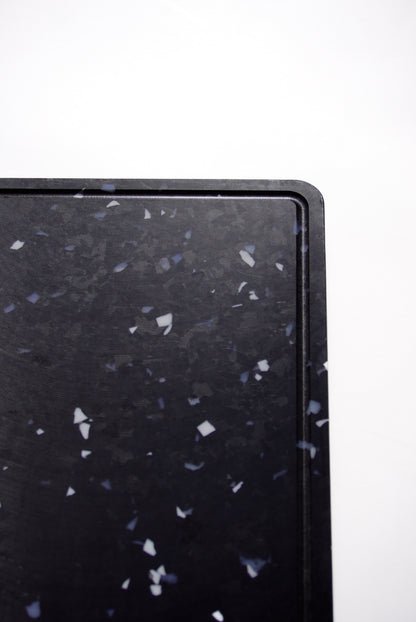 Black chopping board with white and grey speckles
