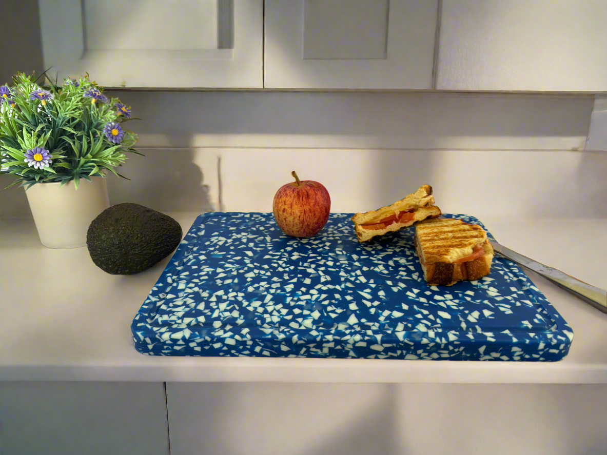 Blue and white speckled cutting board on a kitchen bench top