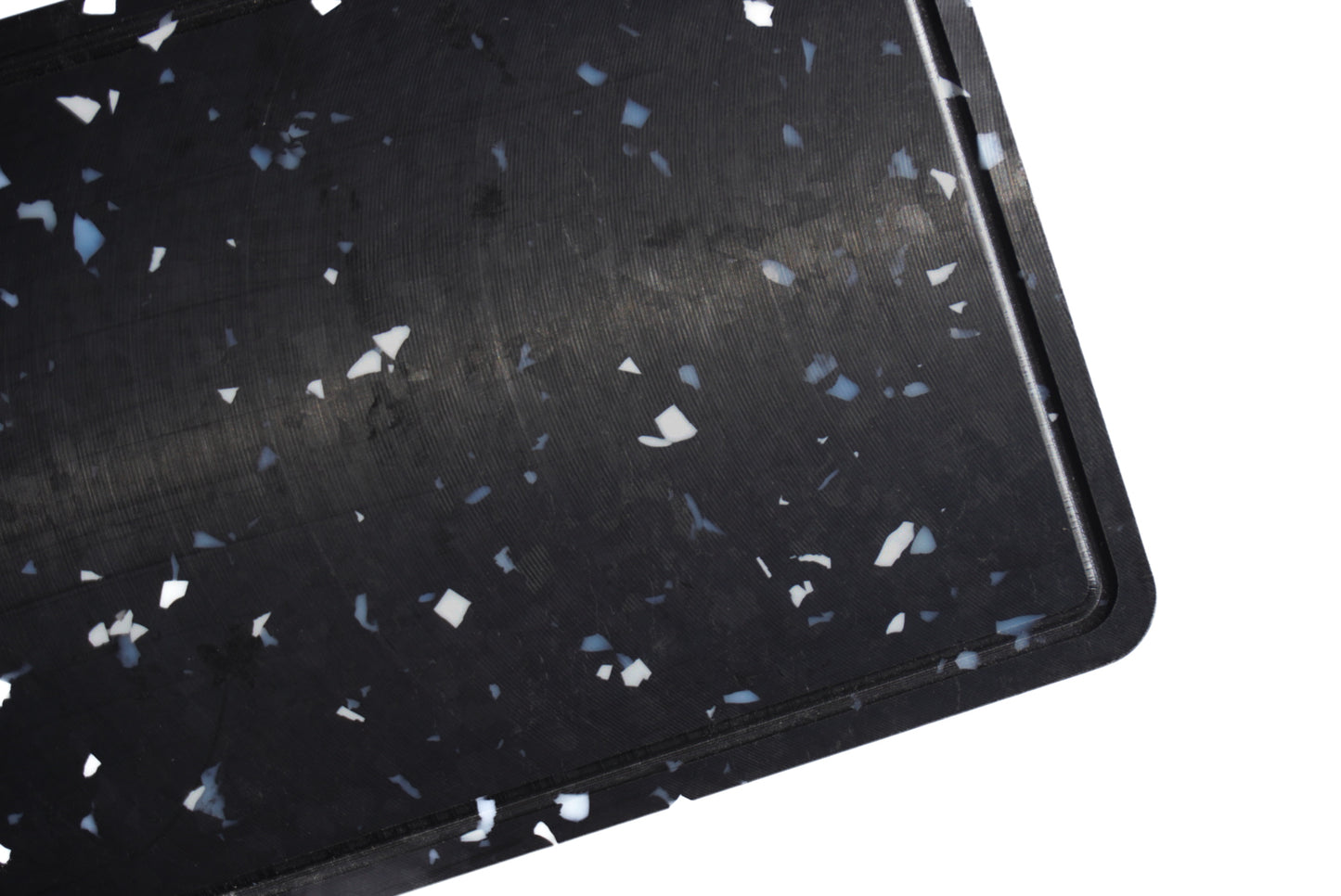 close up of black chopping board with white and grey speckles