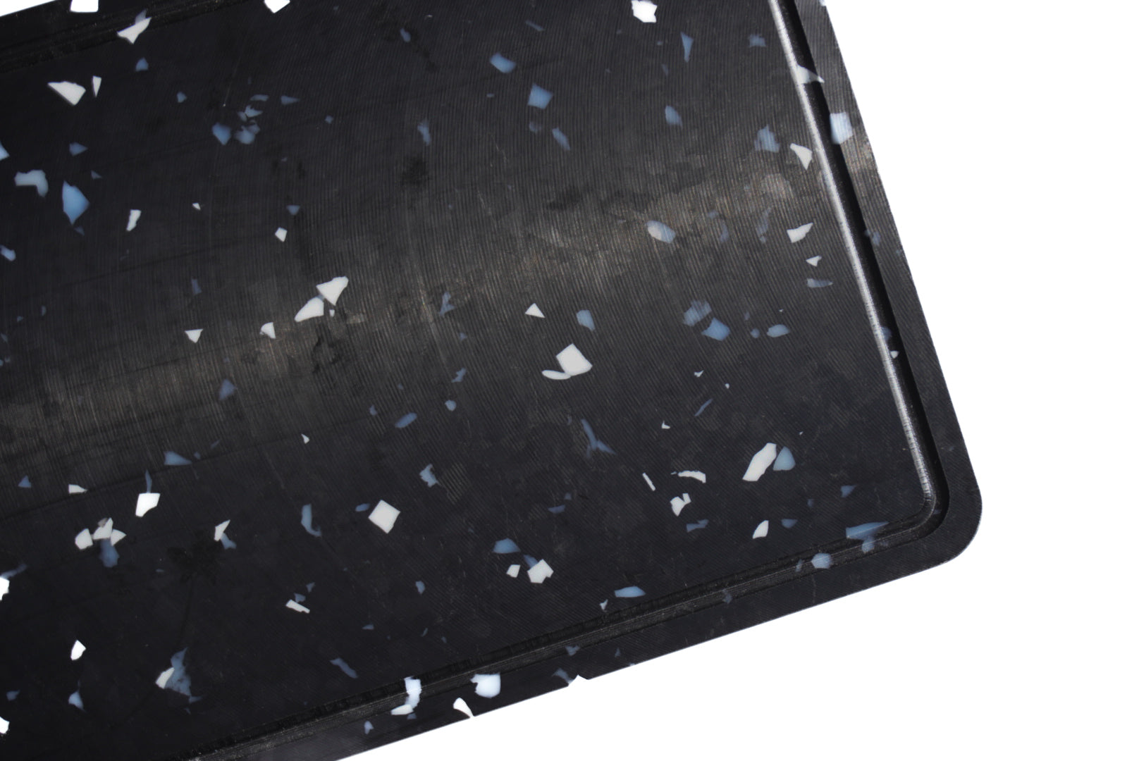 close up of black chopping board with white and grey speckles